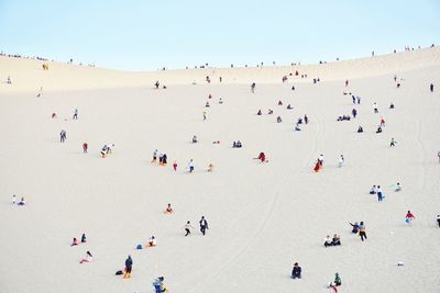 People at beach against clear sky