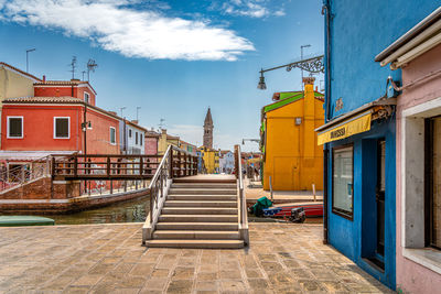 Footpath amidst buildings against sky
