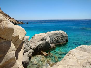 Scenic view of sea and rock formations against clear sky