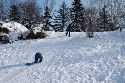 Two children climbing a snow slide. fun in the park.