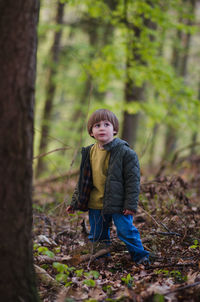 Portrait of boy standing in forest