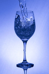 Close-up of wine glass against blue background