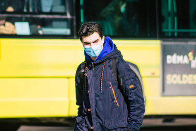 Full length of man standing against yellow wall