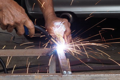 Cropped hand of man welding metal