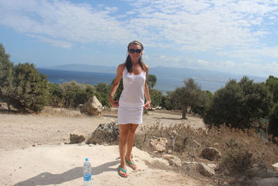 Full length of young woman standing on beach