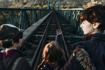 Young friends with compass on a train racks bridge
