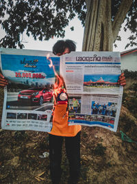 Full length of girl standing by tree