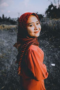 Portrait of woman standing on field during winter