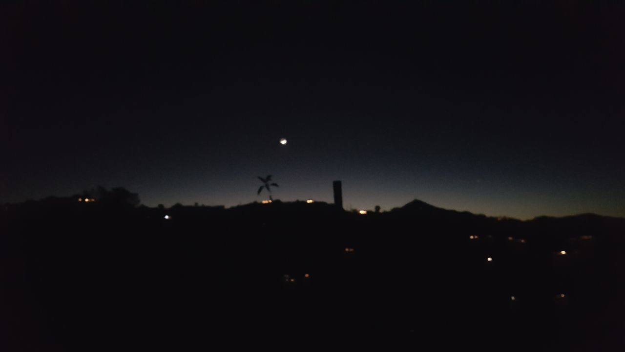 SILHOUETTE WINDMILLS AGAINST MOON AT NIGHT