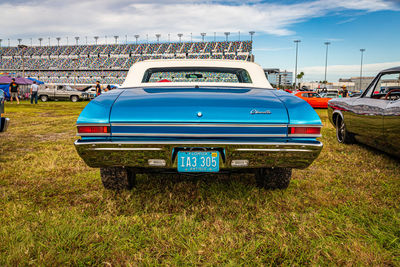 Vintage car on field against blue sky