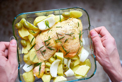 Close-up of hand holding raw chicken