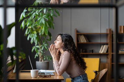 Bored displeased businesswoman worker sit at desk with laptop tired thinking about problem solution