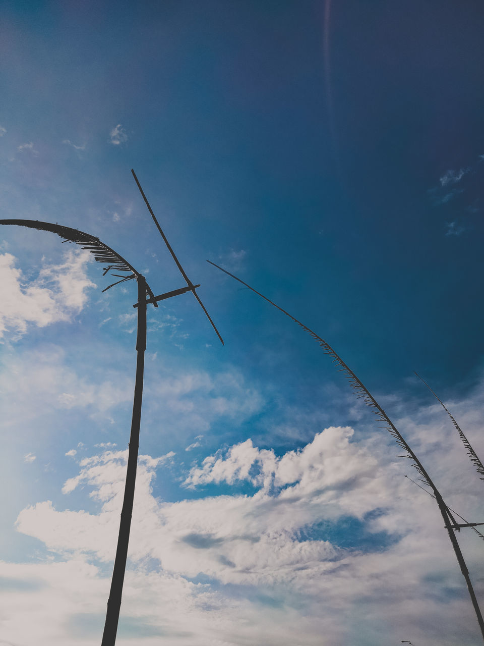 sky, cloud, blue, wind, power generation, nature, electricity, environment, technology, low angle view, renewable energy, line, no people, wind turbine, cable, power supply, environmental conservation, alternative energy, wind power, machine, day, beauty in nature, turbine, outdoors, mast