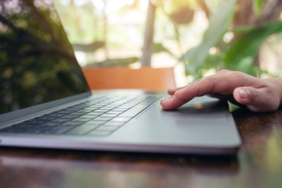 Midsection of man using laptop on table