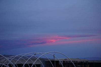 Low angle view of modern building against cloudy sky