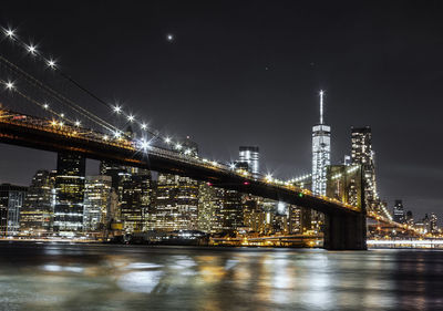 Illuminated bridge against sky at night