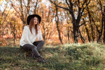 Beautiful woman sitting on grass at park