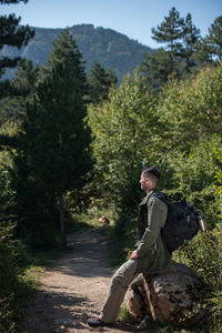 Side view of a man sitting in forest