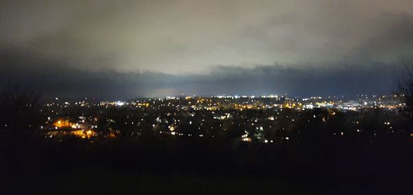 High angle view of illuminated buildings against sky at night