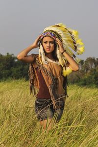 Portrait of young woman standing on field