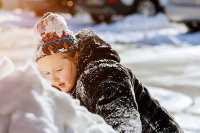 Cute girl playing at snow during winter