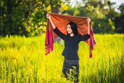 Full length of young woman standing on field