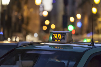 Close-up of taxi text on car roof in city