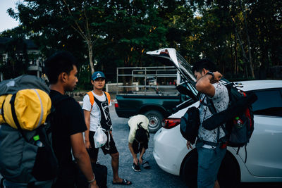 People on street against trees in city