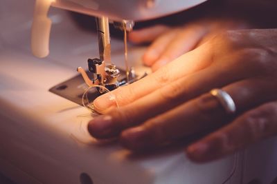 Cropped image of woman using sewing machine