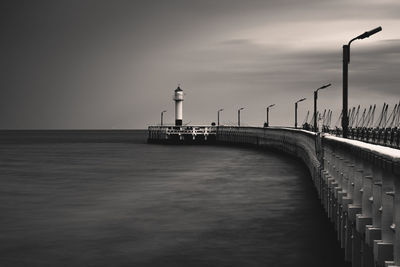 Lighthouse by sea against sky