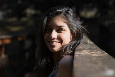 Portrait of smiling young woman at railing