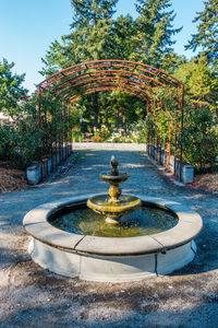 Fountain in park against clear blue sky