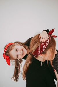 Portrait of smiling young woman with bouquet against white background