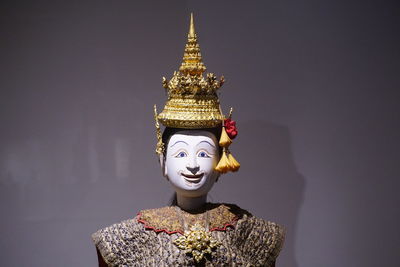 Statue of buddha against colored background