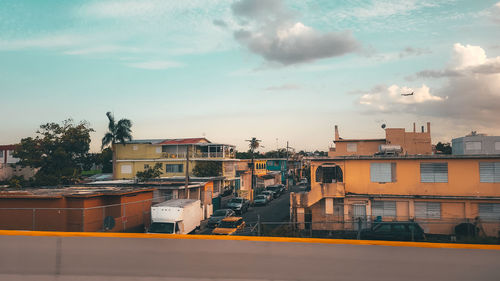 High angle view of buildings by street against sky