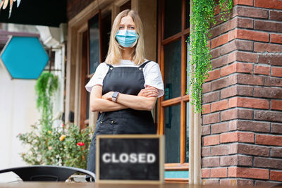Caucasian waitress woman wearing medical mask, cafe  closed. coronavirus covid-19 pandemic
