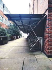 Empty footpath amidst buildings in city