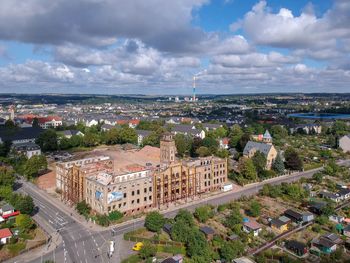 High angle view of city buildings against cloudy sky