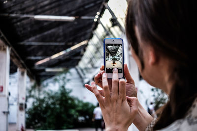Midsection of person photographing with mobile phone