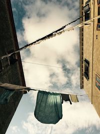 Low angle view of clothes hanging on building against sky