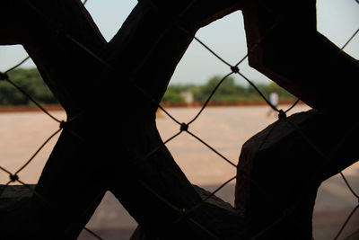 Close-up of silhouette fence against sky