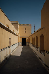 Corridor of building against clear blue sky