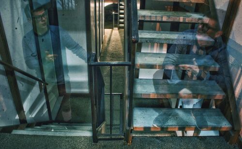 Reflection of man on glass window of building