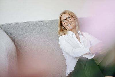 Smiling relaxed businesswoman sitting on couch