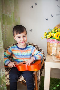 Portrait of cute boy sitting with guitar