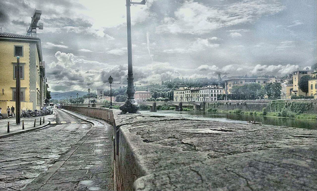 architecture, building exterior, built structure, sky, the way forward, cloud - sky, transportation, diminishing perspective, railroad track, city, street, vanishing point, cloudy, cloud, residential structure, road, house, residential building, day, weather