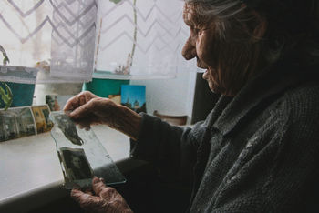 SIDE VIEW OF WOMAN ON WINDOW