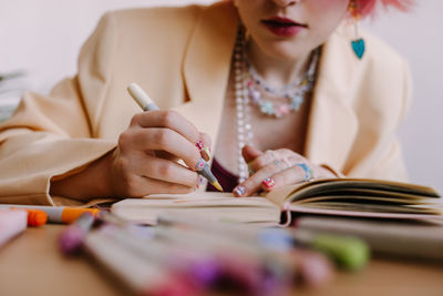 Woman writing on book with felt tip pen