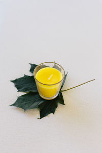Close-up of yellow cup over white background
