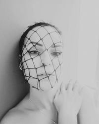 Close-up portrait of shirtless young woman against white background